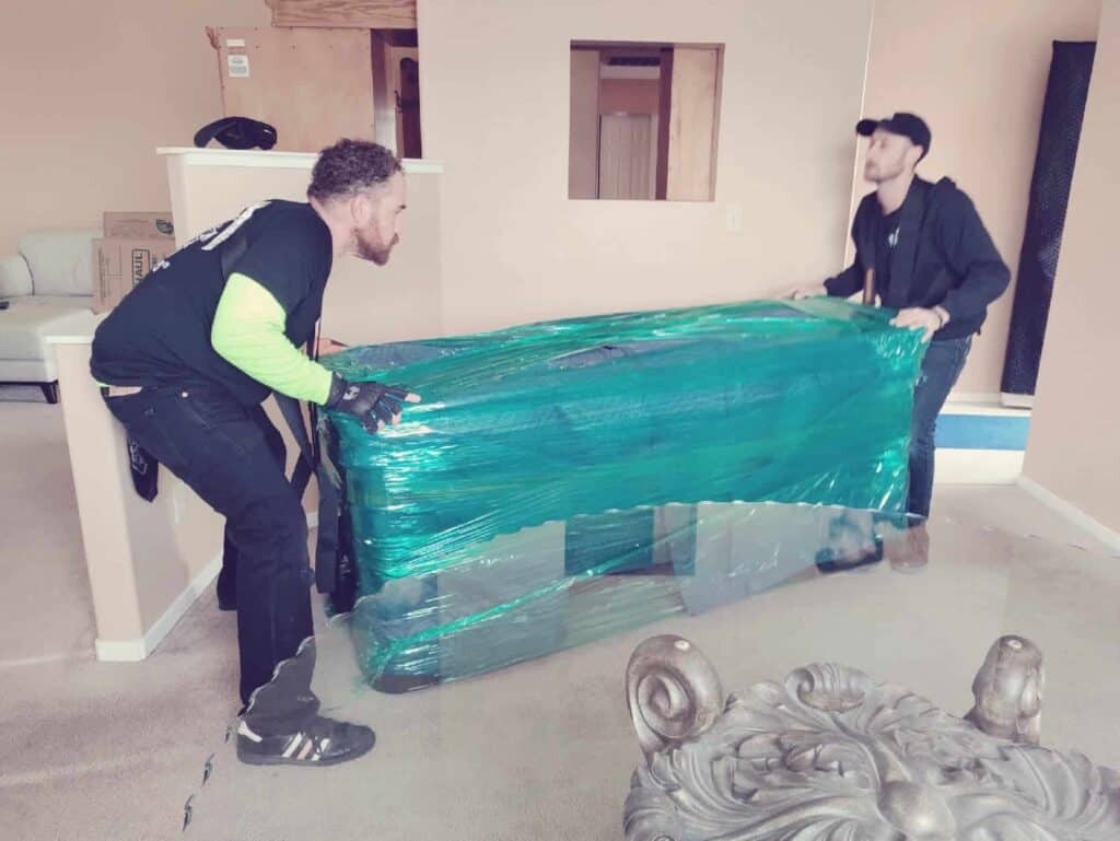 Movers near me carefully packing and loading household furniture with professional equipment and attention to detail